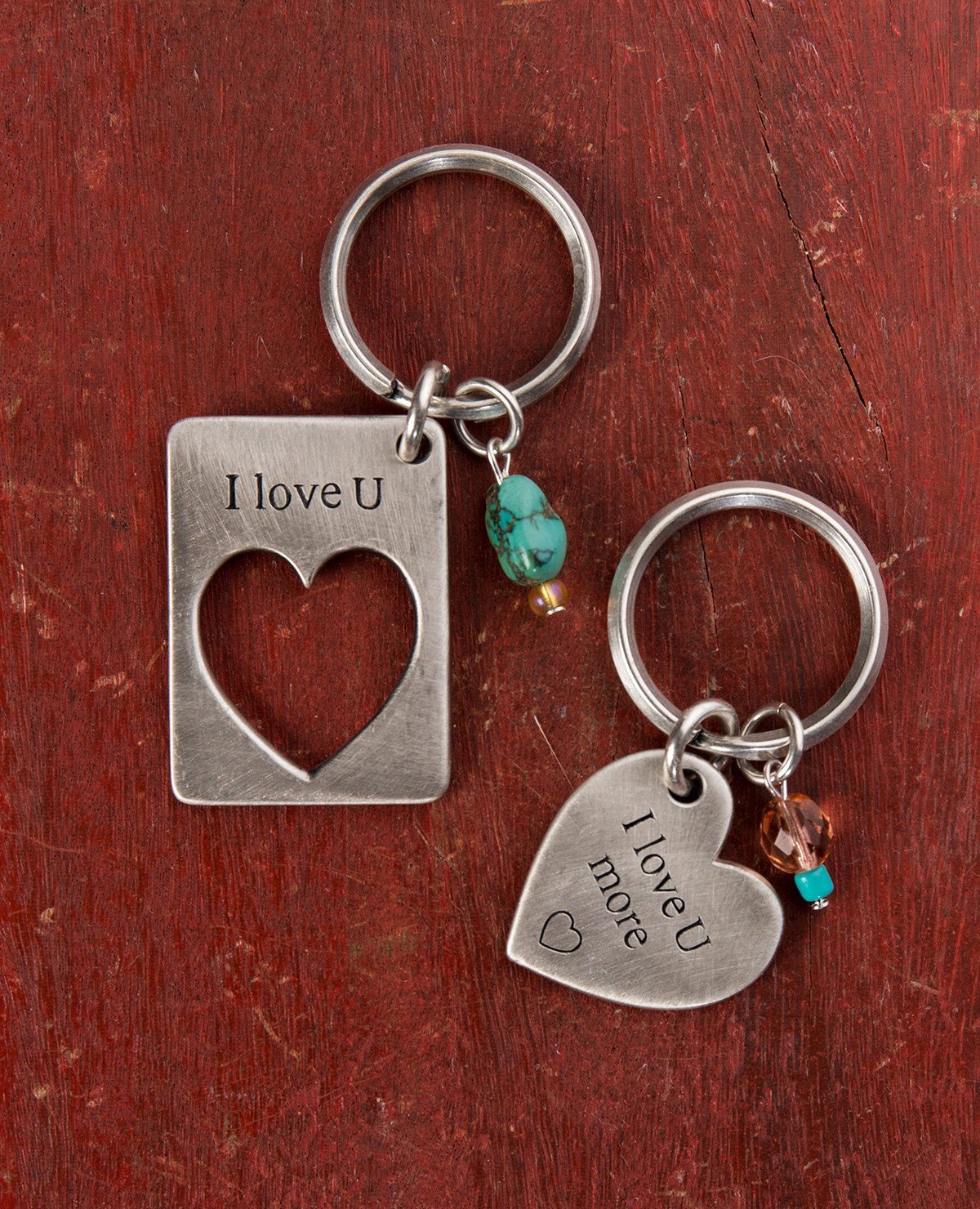 A visually remarkable and extremely romantic pair of keychains.
One is designed as a rectangle with a missing piece in the shape of a heart with the words "I Love U" written on top.
The other keychain is designed in the shape of a heart and has the words "I Love You More" written on it, perfectly completing the piece on the other keychain.
Each one of the keychains is decorated by two colorful beads.
The keychains are coated in sterling silver and are strong and reliable. 
A perfect and romantic gift for an