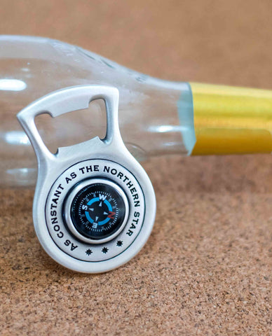A sterling silver beer opener with a compass.  Length: 7 cm  Width: 5 cm